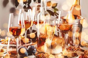Horizontal image of assorted glasses and drinks on a holiday table.