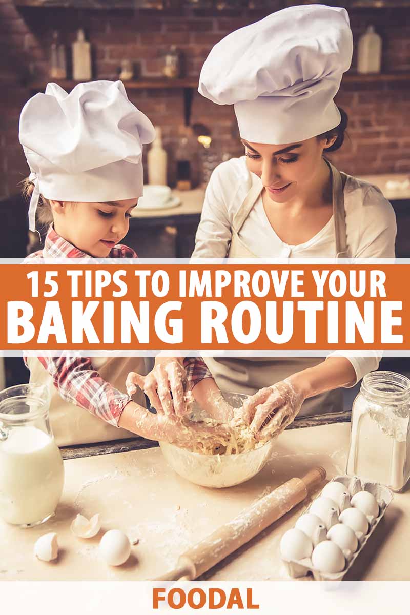 Vertical image of a mother and daughter in the kitchen together wearing chef's hats.