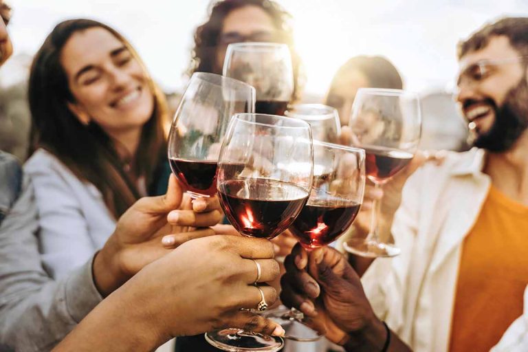 Horizontal image of happy friends toasting outside.