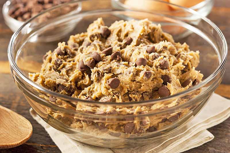 Horizontal image of a glass bowl filled with unbaked dough.