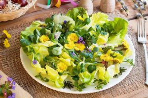 Horizontal image of a salad on a plate with fresh garnishes.