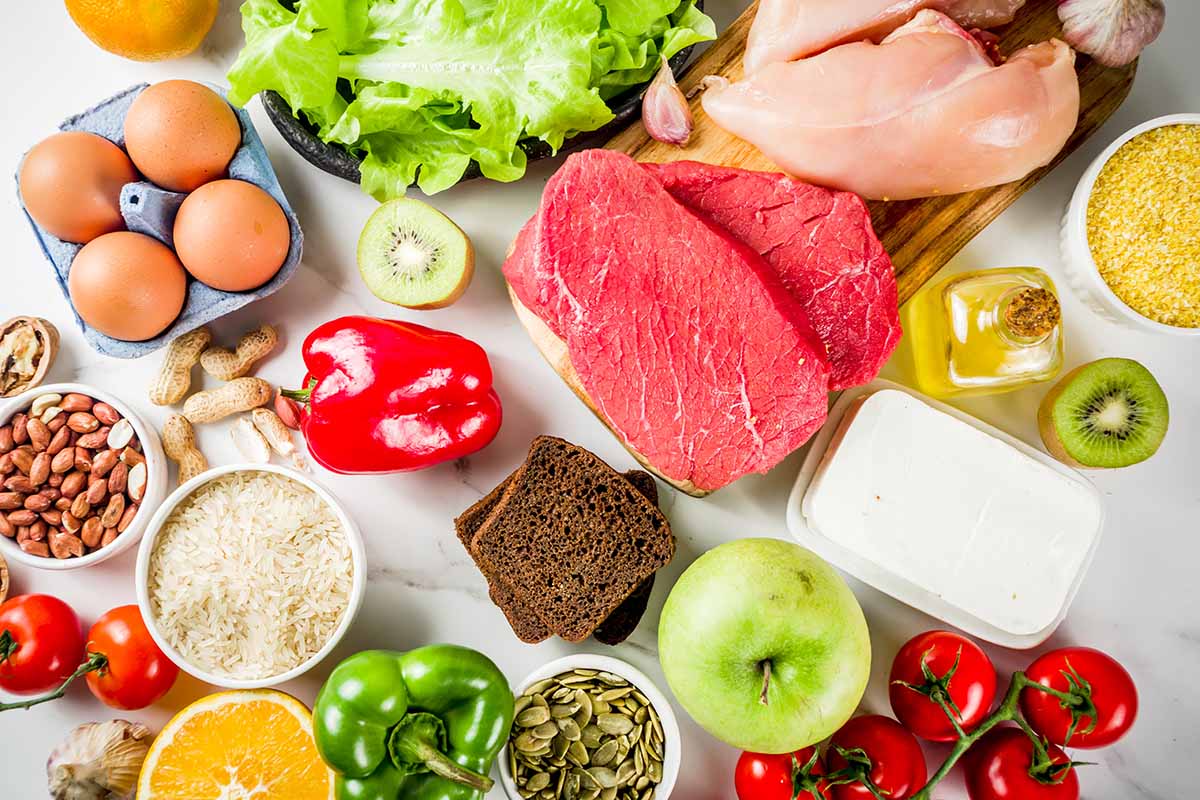 Horizontal top-down image of various fresh and healthy ingredients on a white surface.