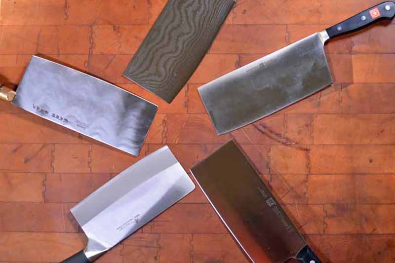 Horizontal image of a circle created with knives on a wooden board.