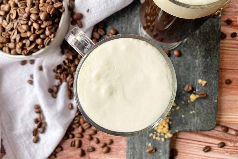 Horizontal image of a white fluffy topping in a glass mug.