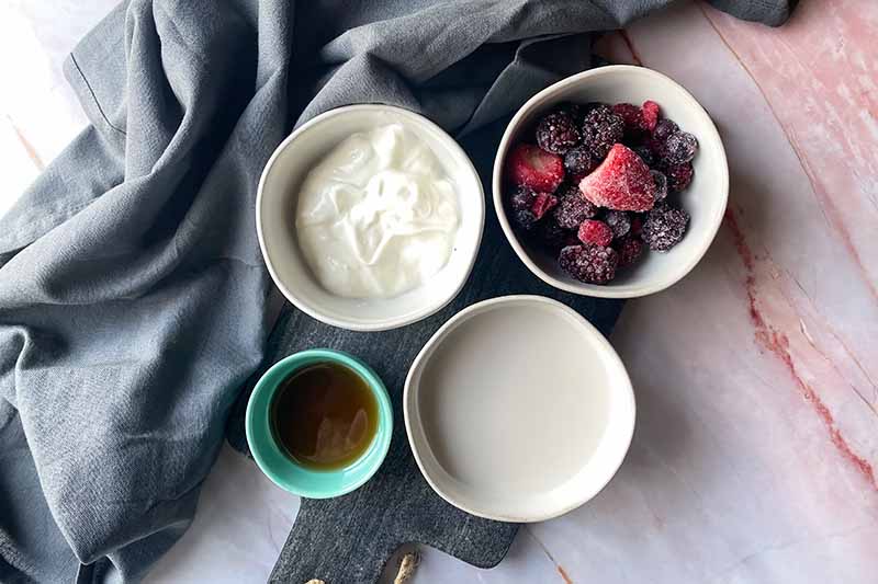 Horizontal image of four bowls filled with measured and prepped ingredients.