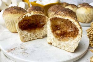 Horizontal image of biscuits, with one split in half to reveal a spiced hollow inside.