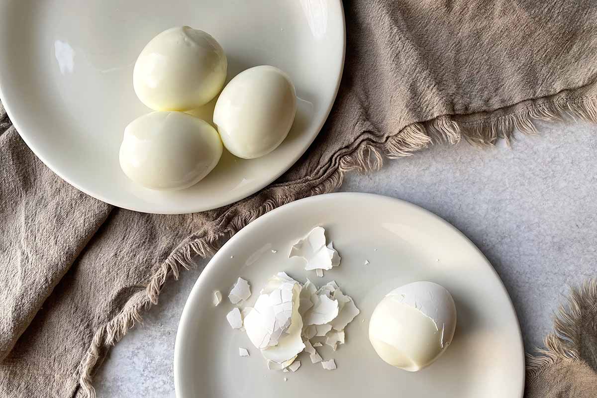Horizontal image of peeling hard-boiled potatoes.