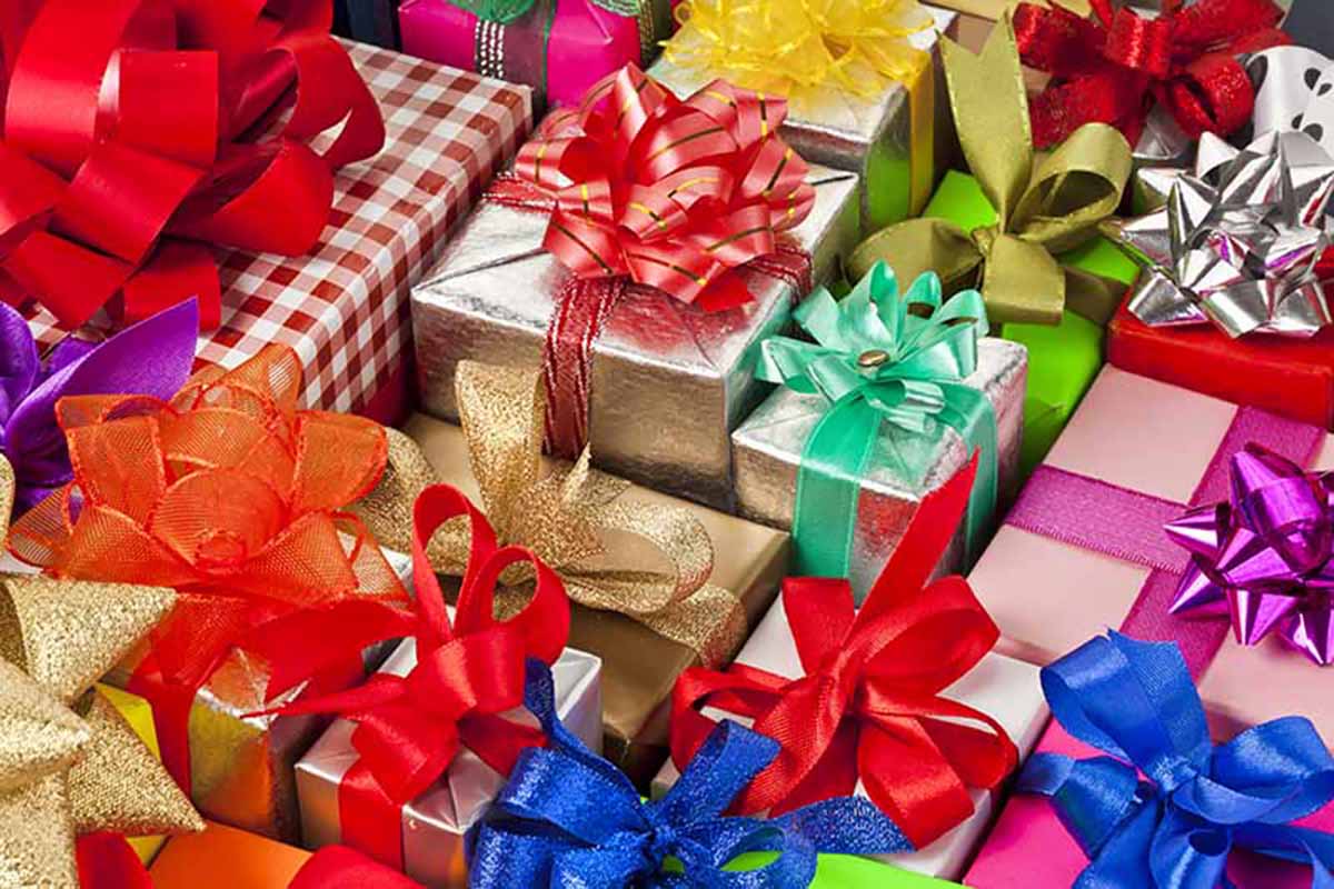 Horizontal image of assorted wrapped presents with ribbons.