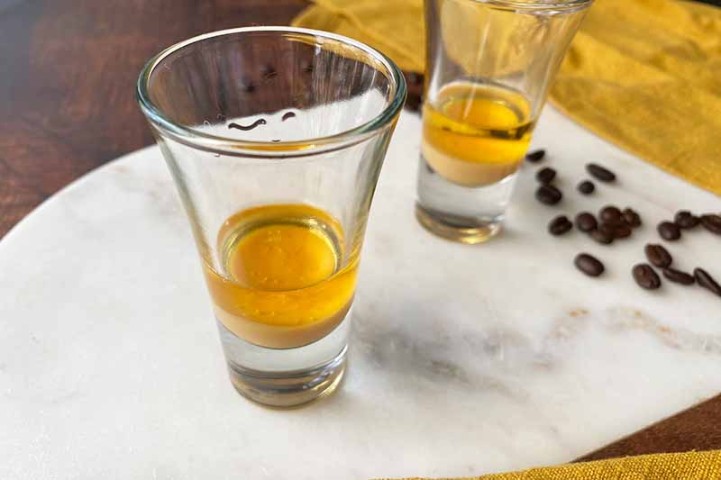 Horizontal image of preparing the layers of a small Tenerife coffee beverage.