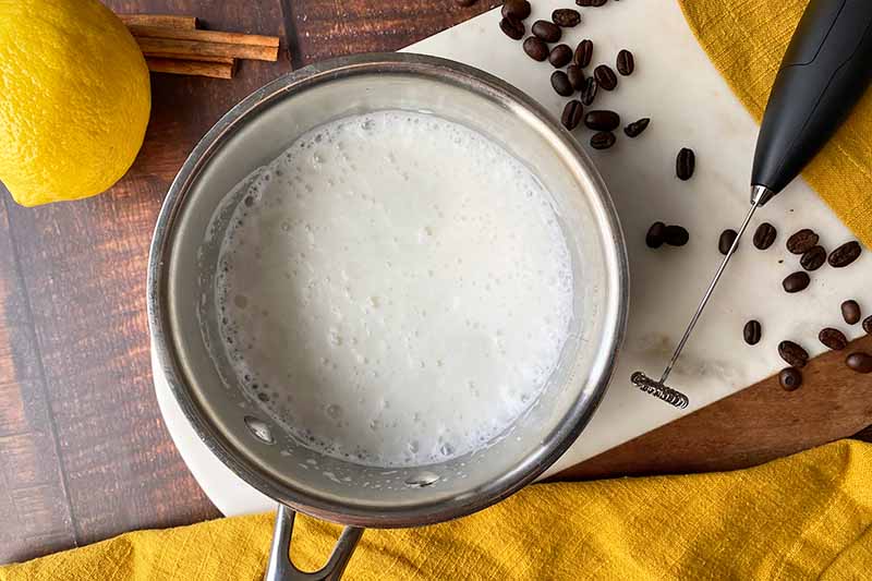 Horizontal image of frothed milk in a pot.