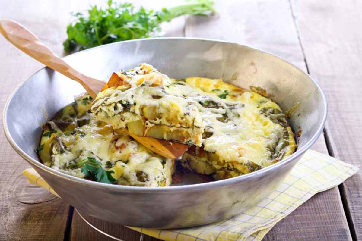 Horizontal image of a frittata cooked in a rice cooker insert.