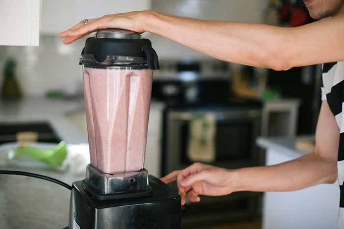 A man makes Pomegranate Melon Apple Aloe Juice in a Vitamix Blender.