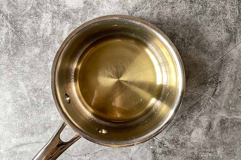 Horizontal image of heating a spirit in a small saucepan.