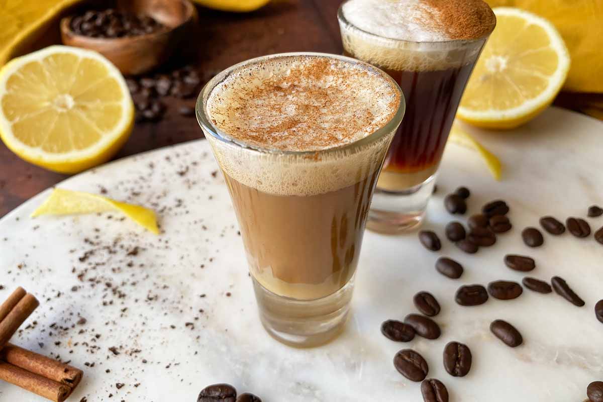 Horizontal image of mixing the layers of a small coffee cocktail.