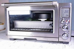 Oblique view of a convection toaster oven being used to prepare roasted stuffed acorn squash