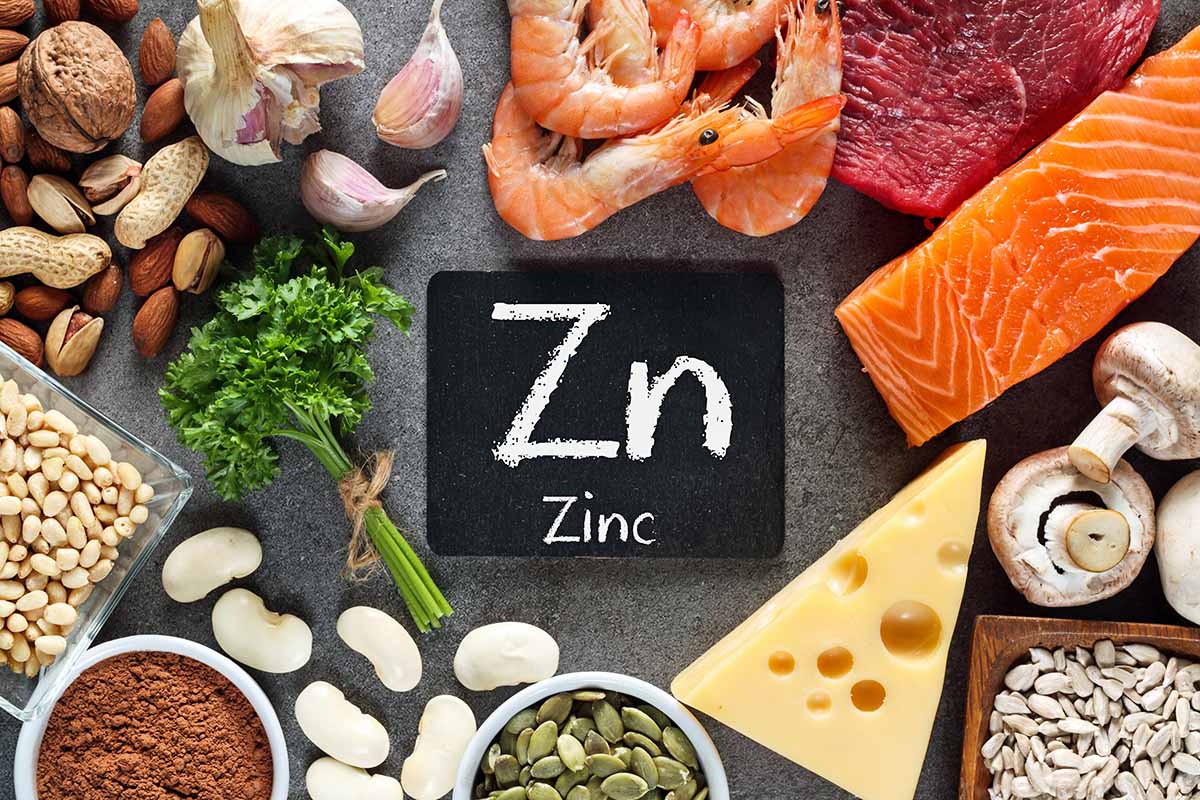 Horizontal image of assorted healthy and fresh foods surrounding a small chalkboard sign in the middle