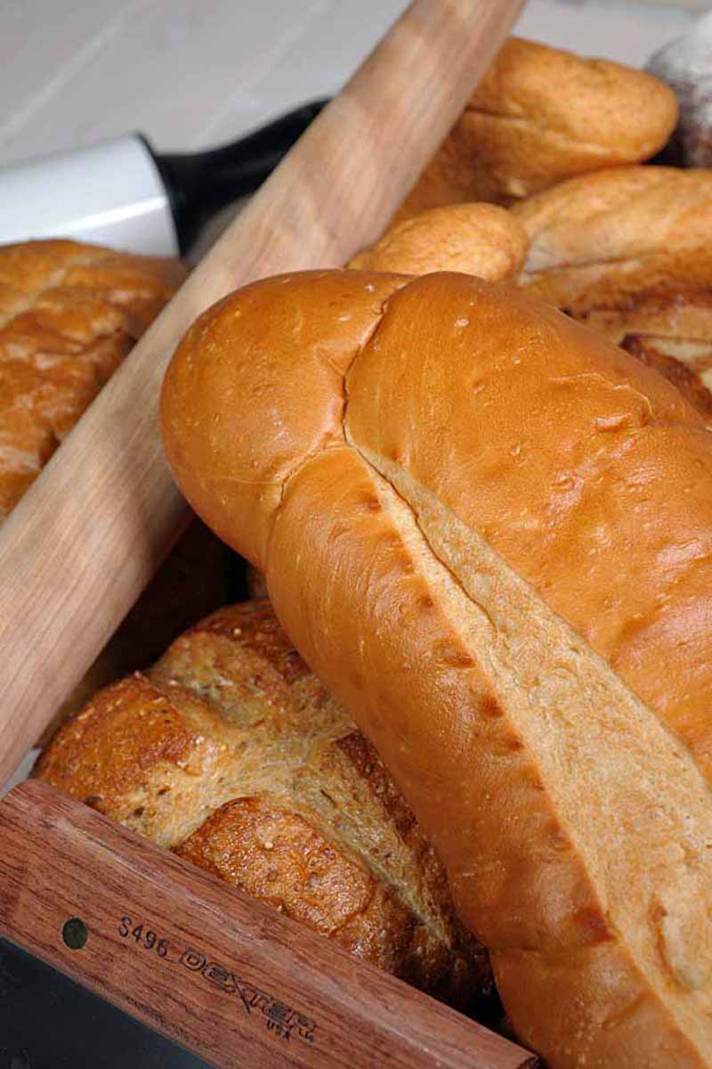 Vertical close-up image of assorted baked goods next to a rolling pin.
