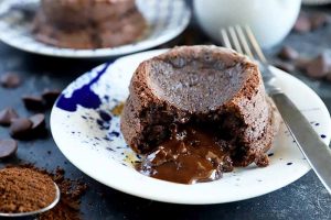 Horizontal image of a molten cocoa desserts on blue and white plates.