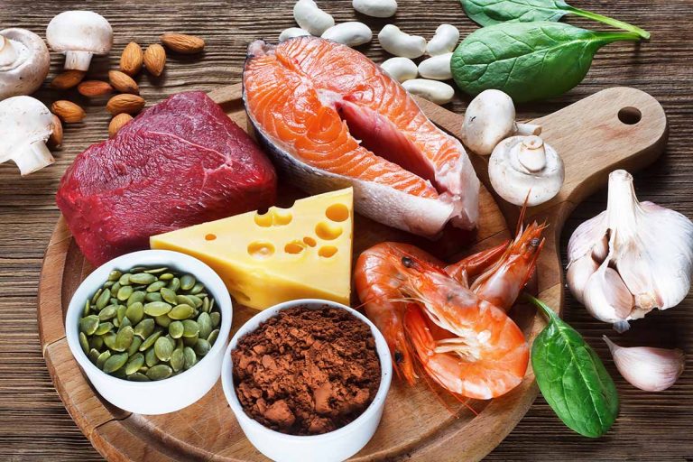 Horizontal image of a display of assorted healthy and fresh foods on a wooden cutting board.